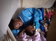 Jemima, survivante d'Ebola, couche Josué, 6 mois, dans une garderie soutenue par l'UNICEF, à Beni, en République démocratique du Congo.